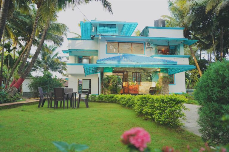Megh Villa, Alibag: The front of the villa across the lawn, with a dining set by the porch