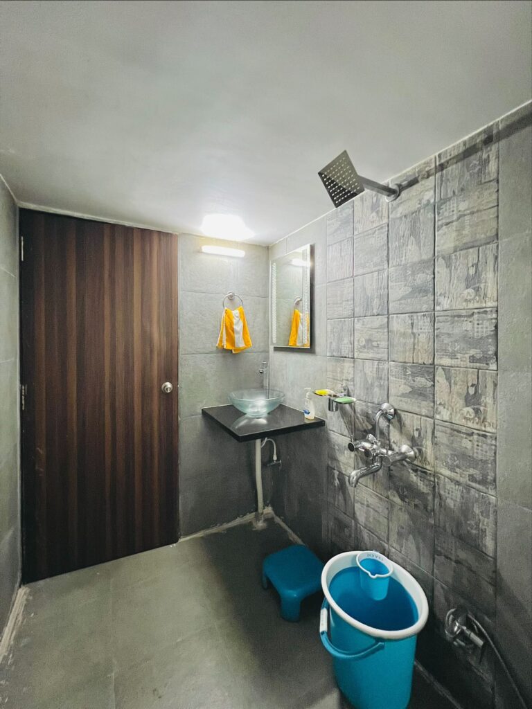 Megh Villa, Alibag: Basin and mirror in the grey-tiled bathroom