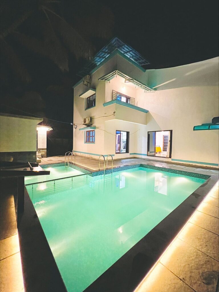 Megh Villa, Alibag: The pool lit up at night beside the villa